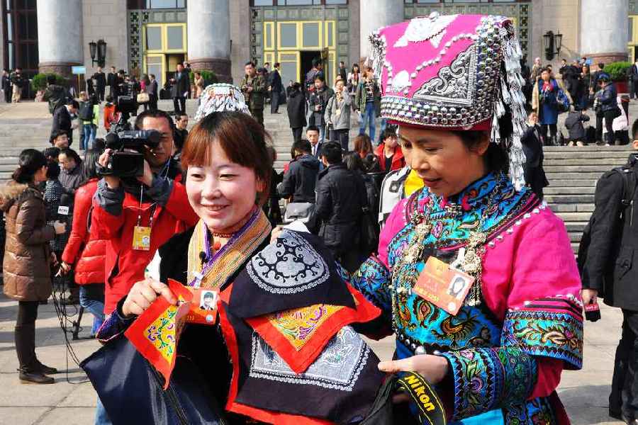 云南代表團(tuán)的兩位女代表在為記者展示她們帶來的民族特色手工藝品。 人民網(wǎng)記者 馬麗婭 攝