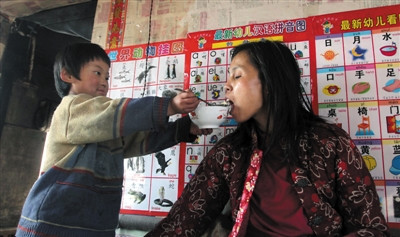 小孫悅為臥床的母親喂飯。